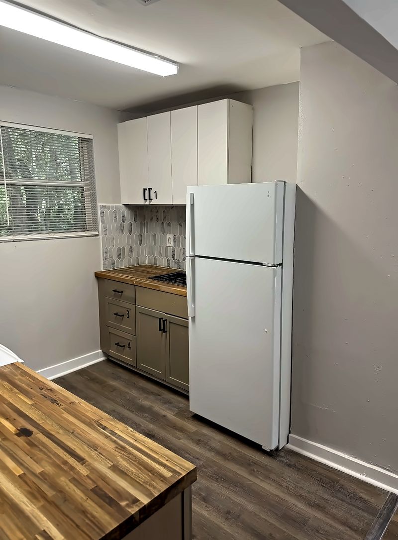 Kitchen with a refrigerator, cabinets, and a butcher-block counter