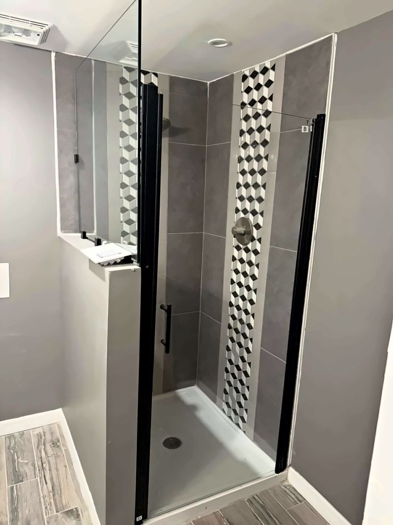 Walk-in glass shower with a tile accent
