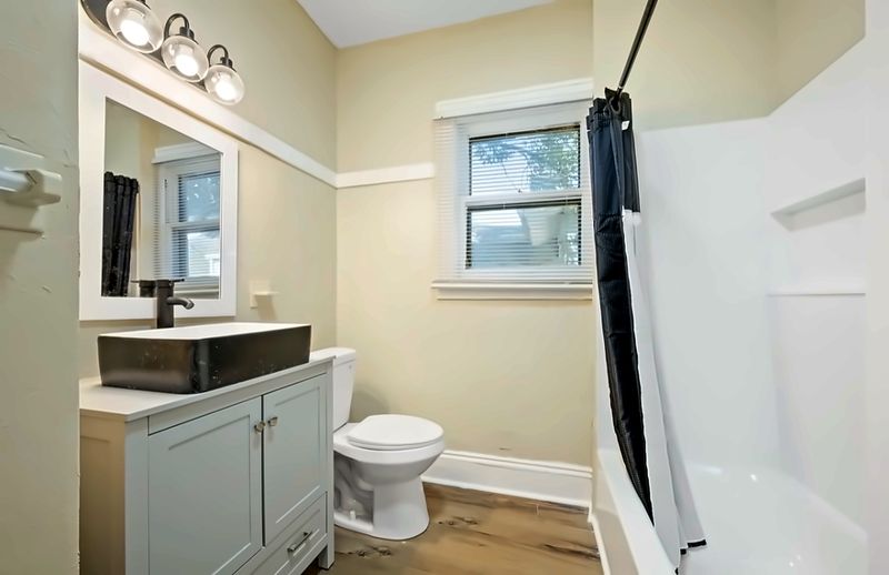 Bathroom with a vessel-sink vanity and a tub with shower